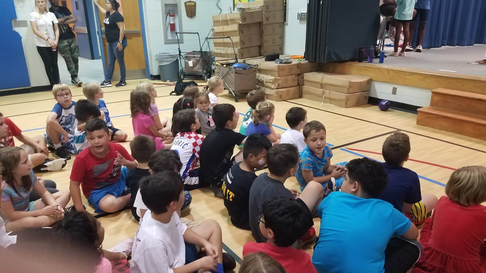 Large group sitting in gym watching