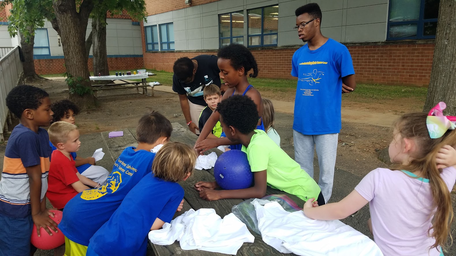 Instructor helping with tie-dye prep at picnic table