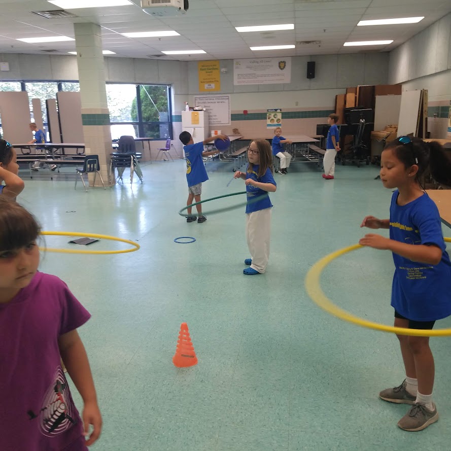 Kids playing with hula hoops indoors